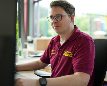 Mitarbeiter von Schüßlers Rohrreinigung arbeitet konzentriert an einem Rechner
